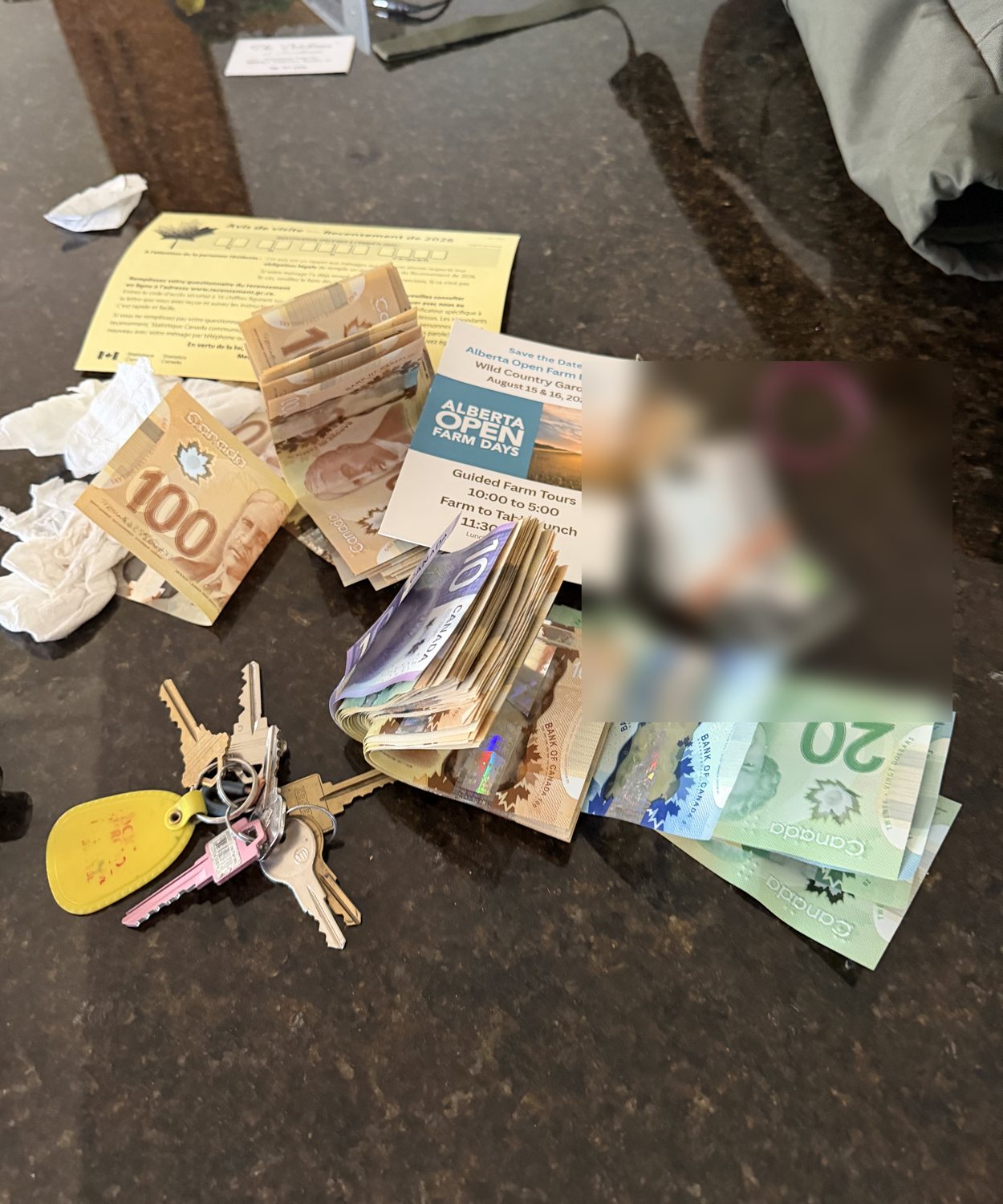 Real last-known evidence showing Canadian cash beside Tim's blurred card bundle and keys